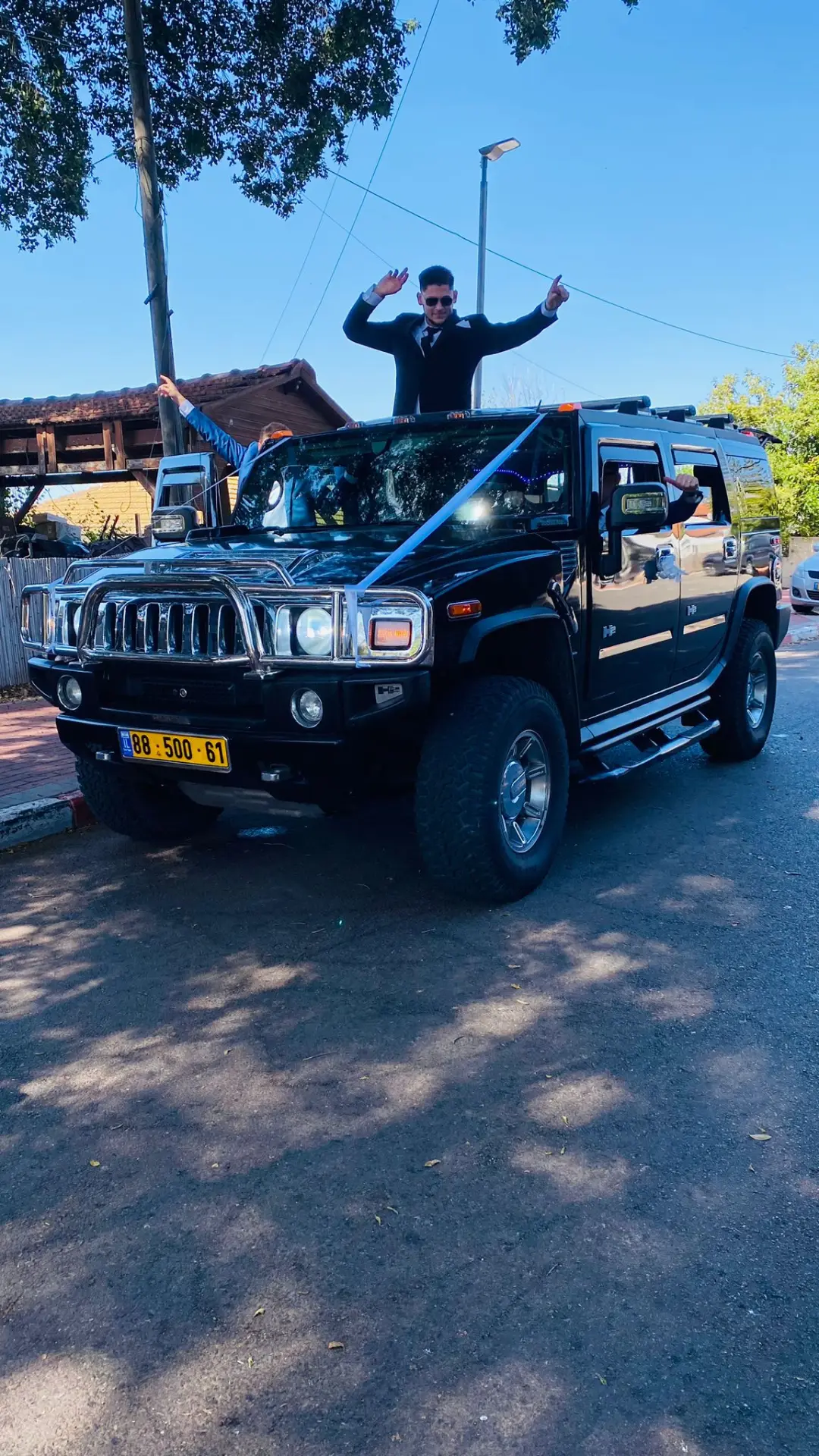 חתן עומד בפתח גג ה-Hummer ביום החתונה